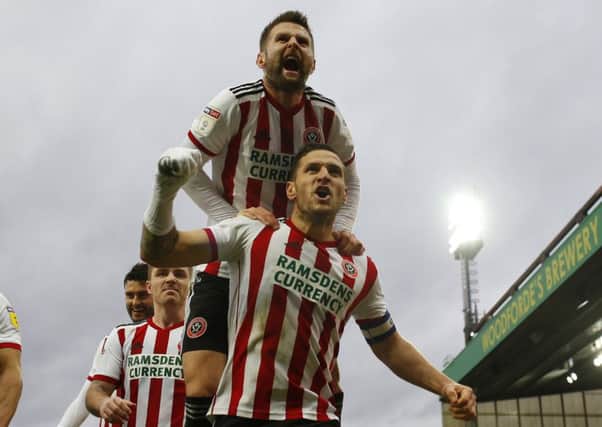 Spot on: Oliver Norwood leaps on Billy Sharp after his successful penalty.