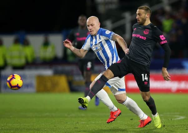 Huddersfield Town's Aaron Mooy (left) and Everton's Cenk Tosun battle for the ball at the John Smith's Stadium. Picture: Nigel French/PA