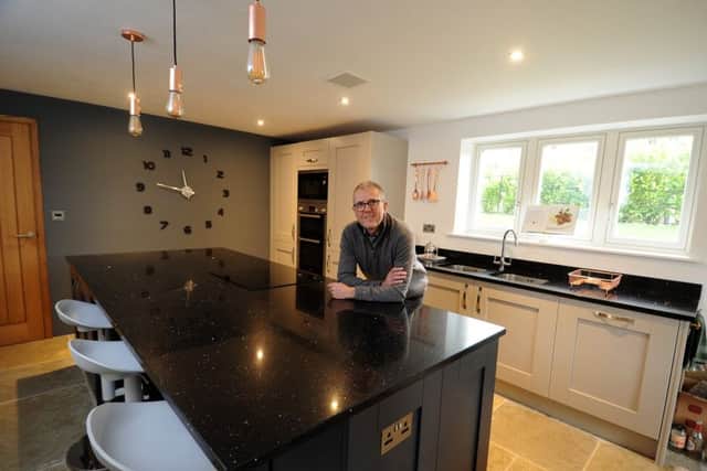 Stephen in his kitchen with cabinets and appliances by Kitchen Design House in Wetherby. The pendant lights are from Heal's at Redbrick Mill, Batley