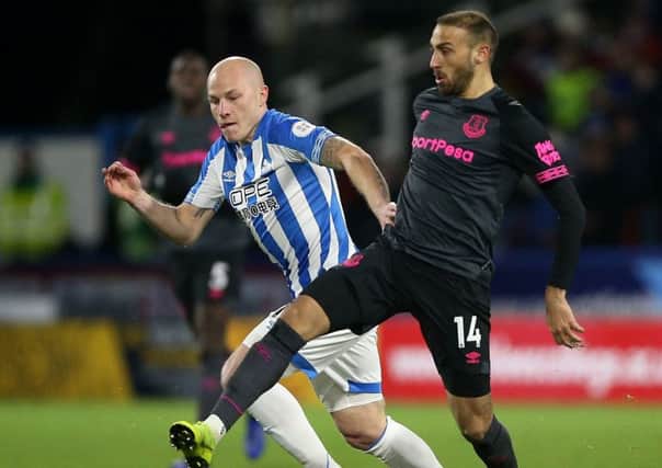 Huddersfield Town's Aaron Mooy (left) and Everton's Cenk Tosun battle for the ball