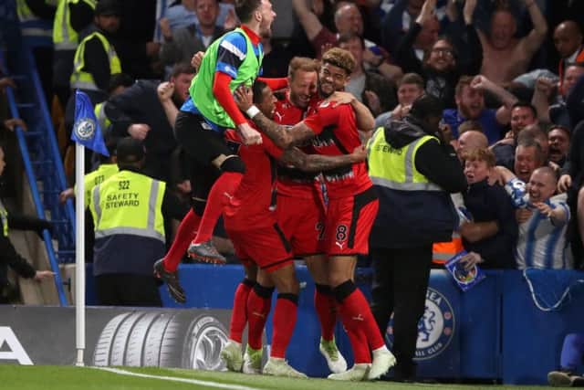 Huddersfield Town's Laurent Depoitre is mobbed by team-mates after his goal earned them Premier League survival last time they visited Chelsea (Picture: PA)