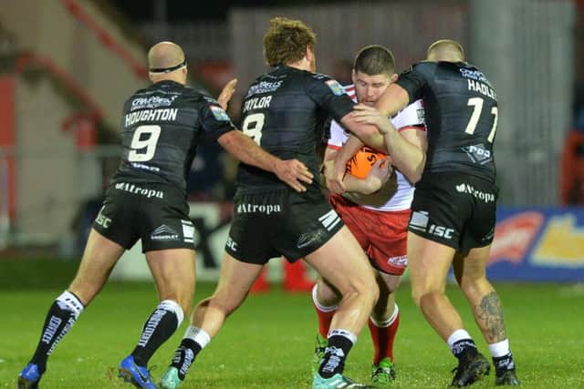 Hull KR's Mitch Garbutt is held up by Hull. (PIC: BRUCE ROLLINSON)