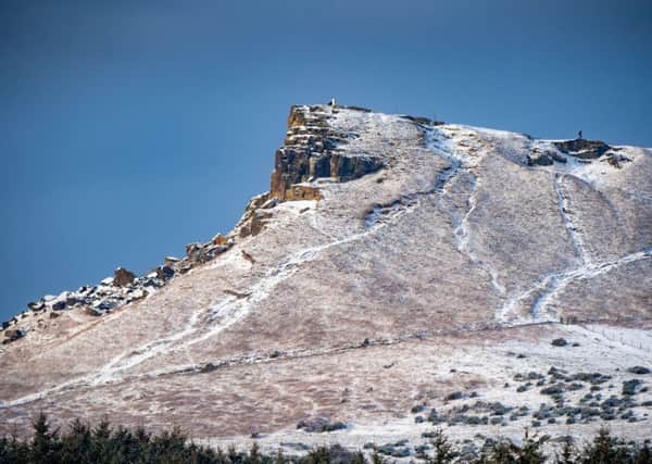 A walker can be seenhiking laong a snow-covered Roseberry Topping. Photo: James Hardisty.