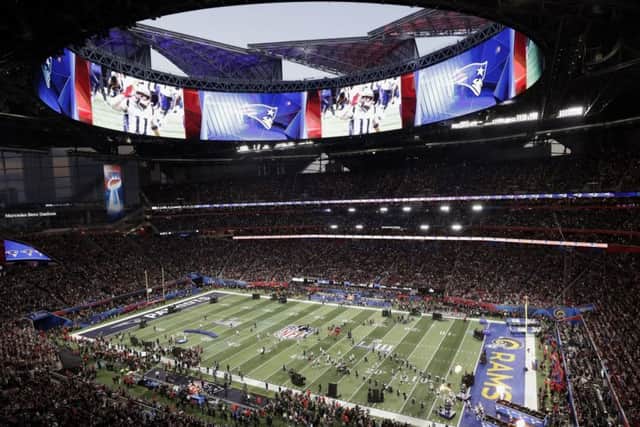 New England Patriots take the field, bottom right, before the NFL Super Bowl 53 football game between the Los Angeles Rams and the New England Patriots Sunday, Feb. 3, 2019, in Atlanta. (AP Photo/Tim Donnelly)