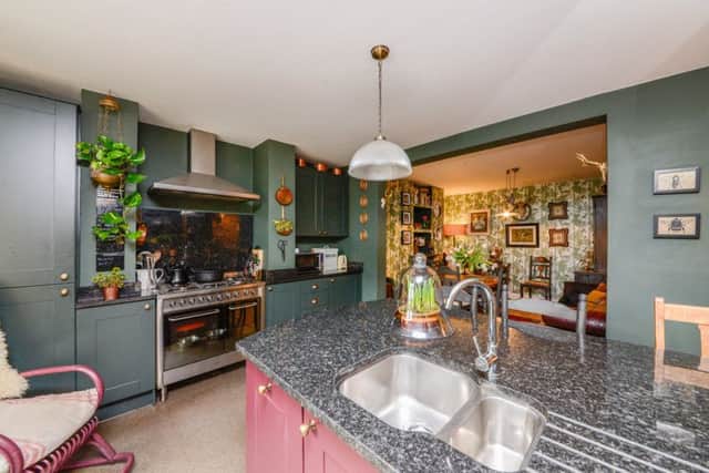 The Shaker-style kitchen units painted in Farrow and Balls Brinjal pink and Studio Green.