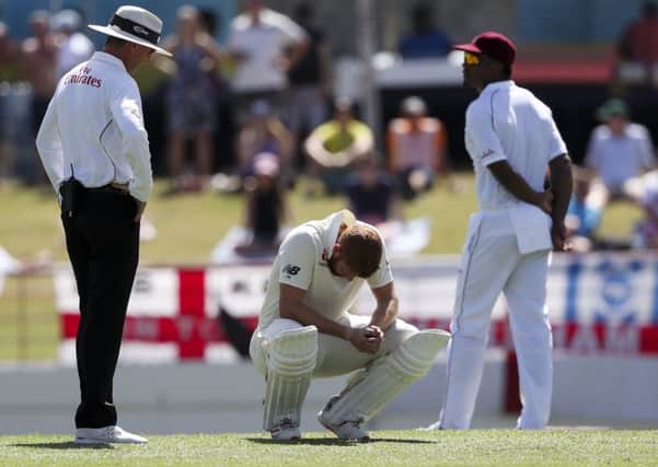 DOWN BUT NOT OUT ... YET: England's Jonny Bairstow crouches after being hit by a delivery during day two in St. Lucia. Picture: AP/Ricardo Mazalan
