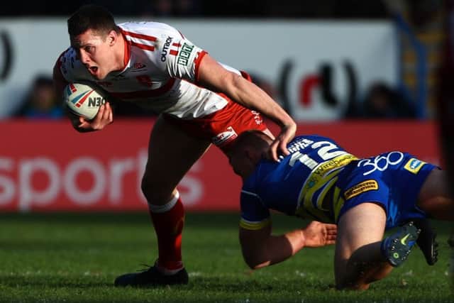 Hull KR's Joel Tomkins is tackled by Warrington's Jack Hughes. Picture: Alex Whitehead/SWpix.com