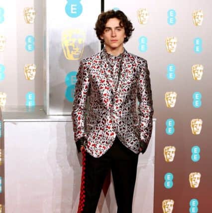 CONFIDENT OPULENCE: Timothée Chalamet - controversially not nominated for this years Oscars for his role in beautiful Boy - hit the Baftas red carpet wearing this Haider Ackermann satin brocade jacket and matching shirt teamed with track-style side-stripe trousers and combat inspired boots. We say, this is exactly how formal meets off-duty should be done. Picture: Jonathan Brady/PA Wire