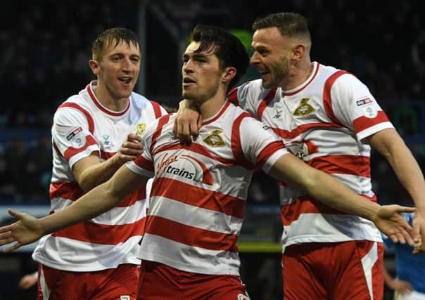John Marquis, who has scored 22 goals so far this season, is congratulated by Doncaster Rovers team-mates after finding the target.