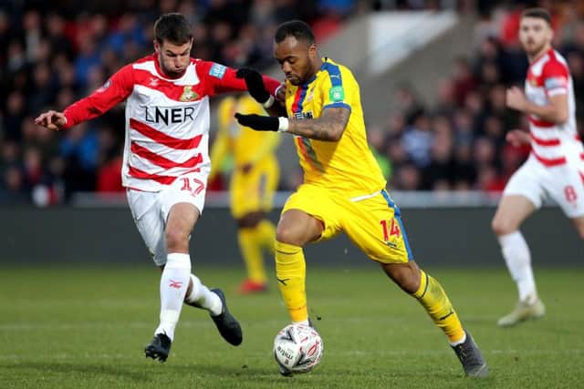 Crystal Palace's Jordan Ayew (right) and Doncaster Rovers' Matty Blair (left) battle for the ball. Picture: Richard Sellers/PA