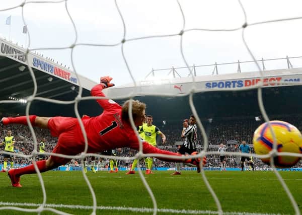 Despairing dive: Newcastle United's Ayoze Perez scores their second goal past Huddersfield's outstanding goalkeeper Jonas Lossl.