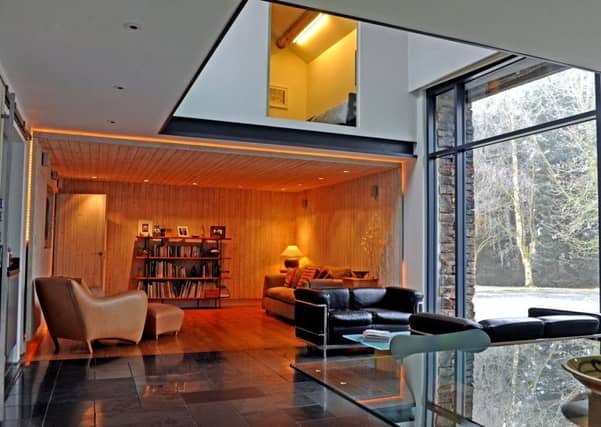 The open plan living space is zoned with a cosy, timber lined TV room at one end and a lighter, brighter sitting area in the centre