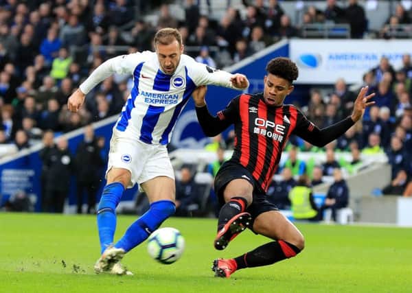Brighton & Hove Albion's Glenn Murray (left) has a shot defended by Huddersfield Town's Juninho Bacuna (right).