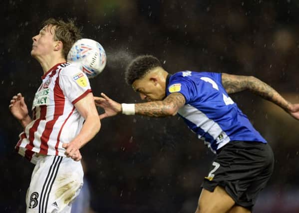 Sheffield Wednesday's Liam Palmer gets the better of Sheffield United's Kieran Dowell in an aerial duel (Picture: Steve Ellis).