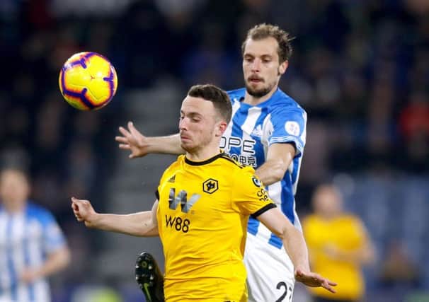 Fighting for his place: Huddersfield Town's Jon Gorenc Stankovic with Wolverhampton Wanderers' Diogo Jota.