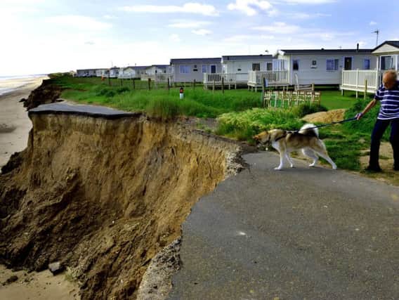 140618 The road to nowhere... a dog walker on the former Ulrome-to-Skipsea road that most sections have fallen into the sea, due to the coastal erosion along the East Coast at Ulrome near Skipsea. Picture by Gary Longbottom.