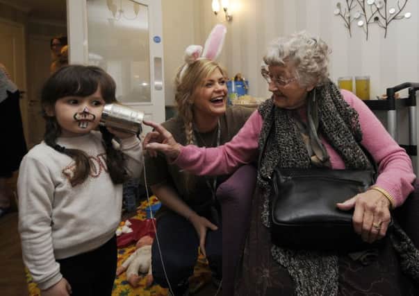Children from The Addy visit residents at Holyrood House, Knottingley. Savannah Lee aged 3 is pictured with Doreen Purkis, with Holly Corbett (centre). Picture by Simon Hulme