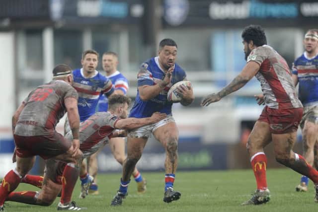 Wakefield player Tinirau Arona charges through the Hull KR defence.