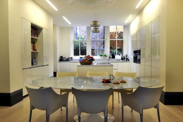 What was a dark, cramped kitchen and separate utility room is now a large, light dining kitchen. The table is by Saarinen and the chairs are by Philippe Starck.