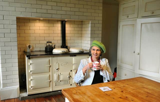 Marcella next to her Aga in the kitchen she made by combining two rooms.