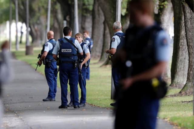 Police keep watch at a park across the road from a a mosque in central Christchurch, New Zealand, Friday, March 15, 2019. Multiple people were killed in mass shootings at two mosques full of people attending Friday prayers, as New Zealand police warned people to stay indoors as they tried to determine if more than one gunman was involved. (AP Photo/Mark Baker)