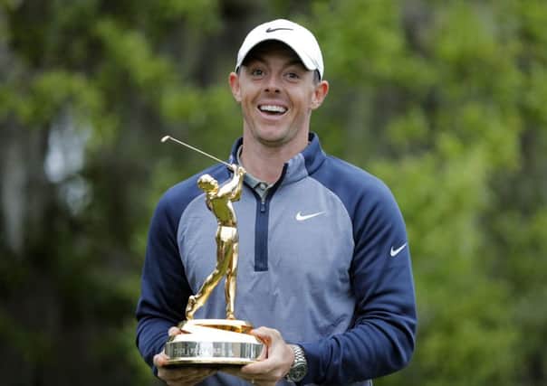 Rory McIlroy poses with the trophy after winning The Players Championship golf tournament.