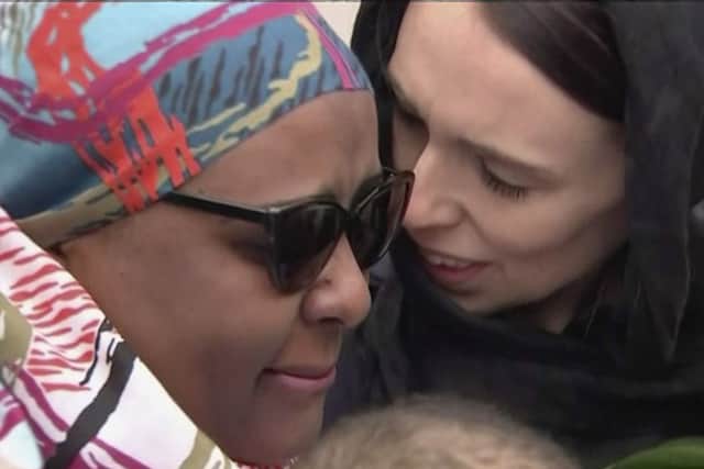 In this image made from video, New Zealand's Prime Minister Jacinda Ardern, right, hugs and consoles a woman as she visited Kilbirnie Mosque to lay flowers among tributes to Christchurch attack victims.