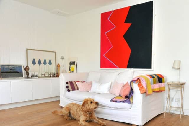 Alfred the dog by the sofa in the living kitchen and above is a painting by Ellie MacGarry.