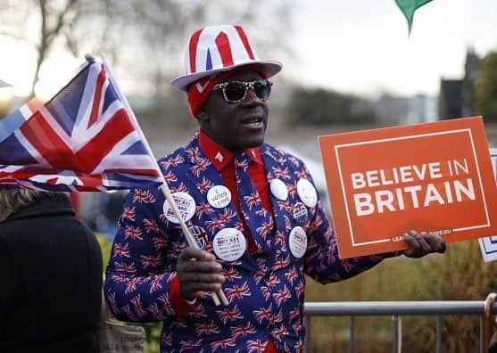 Pro-Brexit supporter, Joseph Afrane waves the Union flag  as he demonstrates outside the Houses of Parliament in London on March 12, 2019, ahead of the second meaningful vote on the government's Brexit deal. - Prime Minister Theresa May's Brexit deal faced a likely defeat in an historic parliamentary vote Tuesday that risked pitching Britain into the unknown just 17 days before its scheduled split from the European Union. (Photo by Tolga AKMEN / AFP)        (Photo credit should read TOLGA AKMEN/AFP/Getty Images)