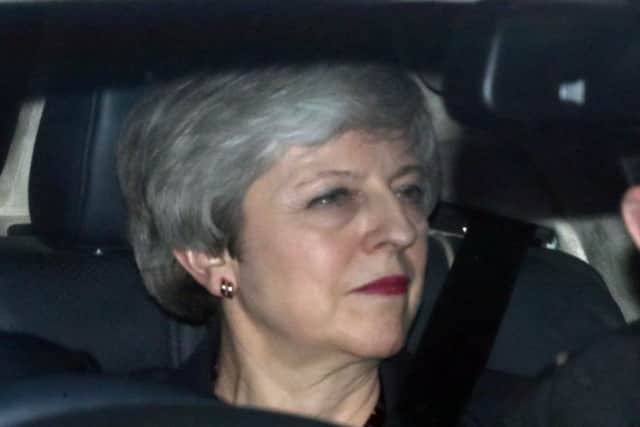 Britain's Prime Minister Theresa May (C) leaves the Houses of Parliament in Westminster, in central London on March 27, 2019. - British Prime Minister Theresa May on Wednesday told Conservative MPs she would step down before the "next phase" of Brexit negotiations, without giving further details on when that might be, an MP at the meeting told reporters. Britain's parliament on Wednesday holds a series of votes to seek an alternative Brexit solution as pressure mounts on Prime Minister Theresa May to resign if she wants her own unpopular plan approved. (Photo by Daniel LEAL-OLIVAS / AFP)        (Photo credit should read DANIEL LEAL-OLIVAS/AFP/Getty Images)