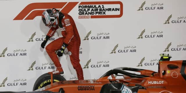 Ferraris Charles Leclerc clambers across his car after having victory snatched from him in Bahrain (Picture: Luca Bruno/AP).
