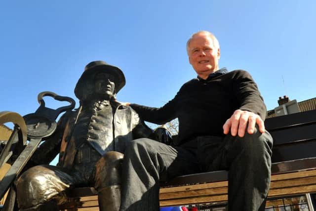 Bernard Higgins from Knaresborough sitting next to the Blind Jack sculpture ,  John Metcalfe  in the Market Place in Knaresborough.