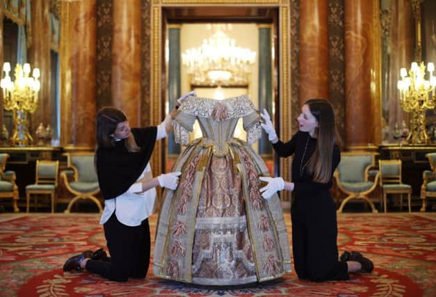 Buckingham Palace staff arranging Queen Victoria's Stuart Ball costume, during the preview for the Queen Victoria's Palace exhibition for the Summer Opening of Buckingham Palace in London.