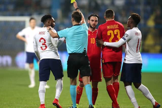 England's Danny Rose, left, is shown a yellow card by referee Aleksei Kulbakov after a foul on Montenegro's Aleksandar Boljevic (Picture: Nick Potts/PA Wire).