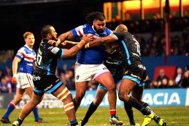 Huddersfield's defence tries to stop the charging Wakefield forward Dave Fifita. (PIC: BRUCE ROLLINSON)