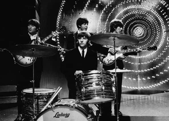 The Beatles perform live on stage in front of a circular lit backdrop at the BBC TV Centre, June 1966. Picture: Getty