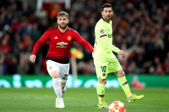 Manchester United's Luke Shaw (left) and Barcelona's Lionel Messi battle for the ball at Old Trafford. Picture: Nick Potts/PA