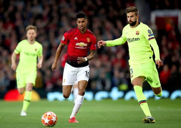 Manchester United's Marcus Rashford (centre) and Barcelona's Gerard Pique battle for the ball at Old Trafford Picture: Nick Potts/PA