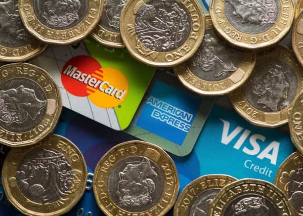 Mastercard, American Express and Visa credit cards with UK one pound coins.