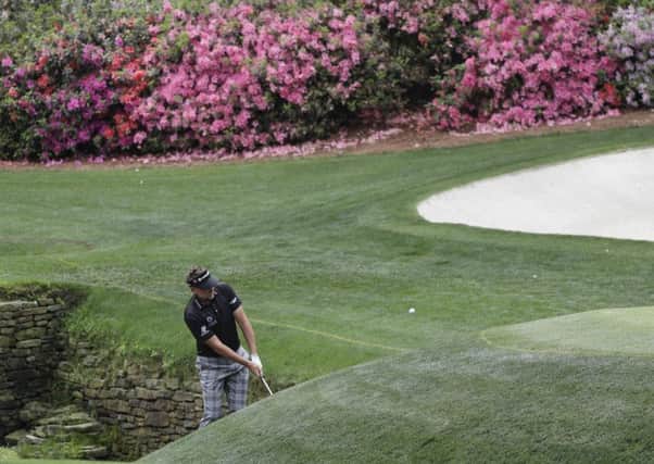 Ian Poulter chips close for a birdie from the bank of Raes Creek at the 13th at Augusta National (Picture: David J Phillip/AP).
