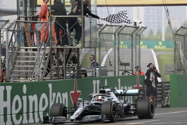 Mercedes driver Lewis Hamilton of Britain drives past the checkered flag to win the Chinese Formula One Grand Prix. (AP Photo/Ng Han Guan)