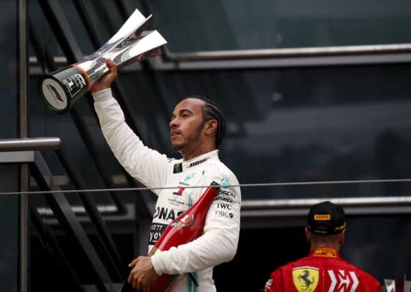 Mercedes driver Lewis Hamilton of Britain celebrates with the trophy after winning the Chinese Formula One Grand Prix at the Shanghai International Circuit in Shanghai. (AP Photo/Andy Wong)