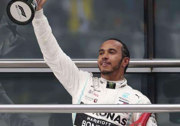 Mercedes driver Lewis Hamilton of Britain raises his trophy to fans after winning the Chinese Grand Prix. Picture: AP/Ng Han Guan