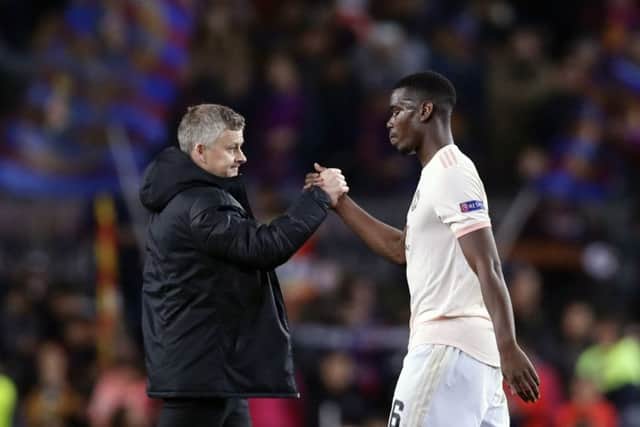 Manchester United coach Ole Gunnar Solskjaer, left, shakes hands with Manchester United's Paul Pogba at the end of the game. Picture: AP/Manu Fernandez