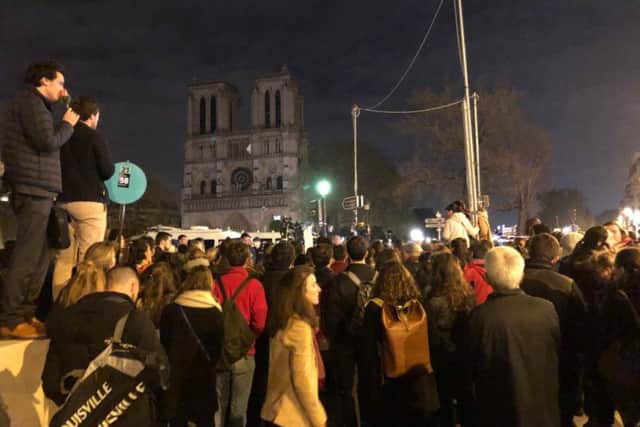 Crowds gather at Notre Dame on Tuesday evening, the day after fire ripped through the Gothic cathedral. Picture: Matthew Lazenby.