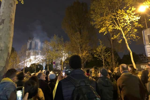 Crowds watch as firefighters battle the blaze at Notre Dame. Picture: Matthew Lazenby.