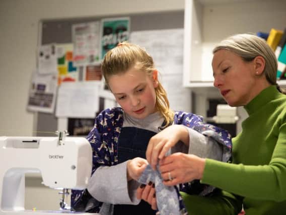 Emma Garry helps a pupil at her sewing class in Ilkley