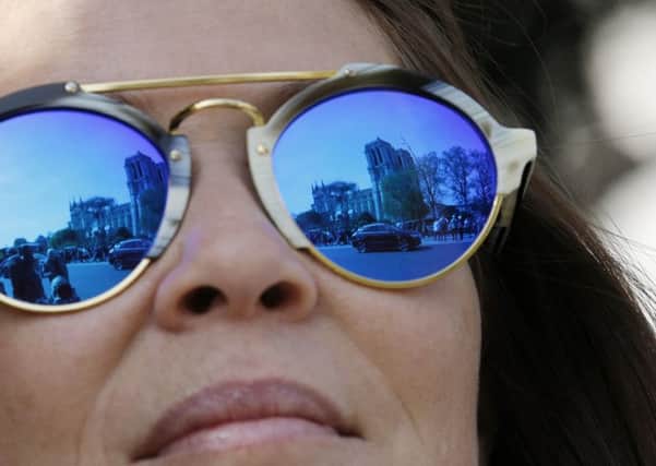 The Notre-Dame cathedral is reflected in the sunglasses of a tourist after last week's devastating fire.
