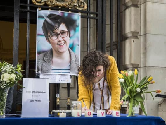 People signing a book of condolence after a vigil at Belfast City Hall in memory of murdered journalist Lyra McKee.