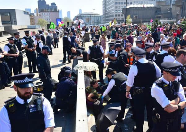 Police remove Extinction Rebellion demonstrators on Waterloo Bridge in London.